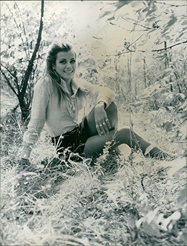 Fotografie de epocă cu Silvia Monti stând pe iarbă, zâmbind.